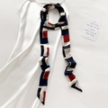 Dettaglio di foulard geometrico in seta con blocchi rossi, blu e bianchi su raso - Nero (Geometrico) / 5*200cm