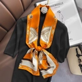 Silk scarf with equestrian print in orange and white over a black sweater - 15*150cm / Orange