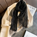 Elegant black long scarf with silver metallic sparkles styled on a beige wool coat - Black