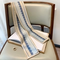 Dettaglio di una sciarpa in seta con stampa leopardata e pizzo su sedia elegante - Pizzo Blu Chiaro Beige