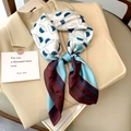 Elegante sciarpa di seta con stampa floreale indossata su blazer beige per un look chic - Azzurro