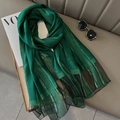 Deep green scarf with gold stripes and black mesh trim on a stylish grey sofa background - Gold Stripe Green