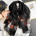 Elegant black silk blend scarf featuring orange daisy embroidery and golden accents - Floral Embroidery Black