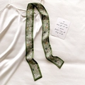 Close-up of olive green floral silk scarf paired with a sleek white satin slip dress - 5.5*118cm / Fruit Green