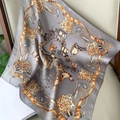 Classic silk scarf with carriage print in grey and orange draped on a leather chair - 53x53cm / Gray