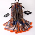 Eleganter Seidenschal mit orangem Blumenmuster drapiert über einer schwarzen Handtasche - Oranger Rand (F-153)
