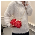 Red sequin evening bag with sparkling texture and diamond clasp on white fuzzy cardigan - Red