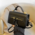 Black PU leather crossbody bag with dual tassel zippers and gold hardware accents - Black