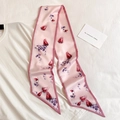 Detail eines rosa Seidenschals mit Rosenmuster auf weißem Shirt mit Karte - Rosen-Blumenprint / Rosa