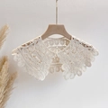 Detail of hollow lace shawl with floral embroidery and a small pearl buckle closure - One Size / Beige