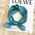 Detail of silk square scarf in teal satin finish tied in a ring knot on a white board - 53*53cm / Lake Blue