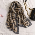 Linen feel geometric pattern scarf in earth tones laid on bed with a chain bag - Geometric Greek Key (A-230-Khaki)