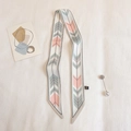 Detail of silk skinny scarf with geometric patterns and pearl brooch on fabric background - TLP-74 Beige Pink (Geometric Arrows)