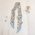 Close-up of a floral silk scarf with daisy prints and blue border on a soft textured fabric - TLP-76 Water Blue Border (Daisy Print)