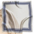 Eleganter Seidenschal mit marineblauem Geometriemuster auf weißem Hemd liegend - Marineblau