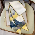 Detail of skinny silk scarf with abstract mountain print on book with pearl brooch - Oil Painting Yellow