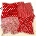 Detail of red and white silk scarf with mixed paisley and polka dot print patterns - Red