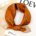 Detail view of smooth silk square scarf with orange tones and equestrian horsebit patterns - Orange (Retro Belt Buckle)