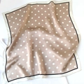 Close-up of lightweight silk square scarf with white polka dots on apricot background - Beige