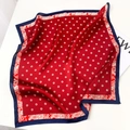 Close-up of silk square scarf featuring red and blue paisley patterns with polka dots - Red