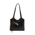 Macro view of a glossy black leather tote bag with unique key and cord charm - Black