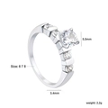 Macro detail of a 5.5mm round zircon stone in a six-prong setting on a silver ring - US 6 / Six-Prong Round with Three Side Diamonds Style (RI1602A6-8S)