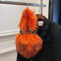 Herzförmige Handtasche aus orangefarbenem Waschbär-Kunstpelz mit weicher Textur und Metallring - Orange