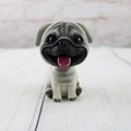Detailed close-up of a pug bobblehead car ornament with lifelike resin textures - Pug