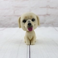 Detailed view of yellow labrador puppy car dashboard ornament showing lifelike fur texture - Labrador