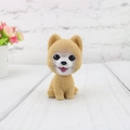 Close-up of resin shaking head dog dashboard ornament with realistic fur texture - Pomeranian