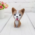 Macro detail of a resin nodding dog car ornament with realistic fur texture and cute face - Corgi