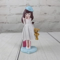 Detail of girl figurine with teddy bear and pink suitcase on heart-shaped base - White Letter D
