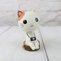 Macro detail of resin cat figurine with camera on tree stump for home car decor - Shaking Head Ornament - White Cat with Camera