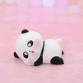 Niedliche Panda Kuchendekoration in Krabbelpose auf weichem rosa Bokeh Hintergrund - Schläfriger Panda-Stil