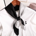 Primer plano de un elegante pañuelo de satén negro y plateado en una camiseta blanca - 70x70cm / Negro y Gris