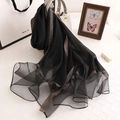 Elegant semi-transparent black scarf with gold wave patterns draped on a white handbag - Black Gold Wire