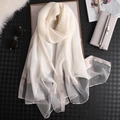 Elegant white semi-transparent silk scarf with gold bead trim on a black background - Cream