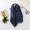 Solid deep blue cotton linen scarf with tassels displayed on a wooden hanger with books - 110*200cm / Navy Blue