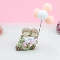 Figurine de gâteau couple sur scooter vert avec des ballons pastel pour décoration - Couple en Scooter avec Ballons Oranges