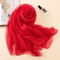 Detailed close-up of a vibrant red silk scarf folded into an elegant rose shape texture - Red