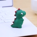 Niedliche grüne Mini-Dinosaurier-Figur auf Laptop-Tastatur für Büro-Schreibtischdeko - Grün