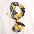 Slim silk scarf with yellow and black houndstooth pattern tied in a bow on white fabric - Yellow Black Houndstooth