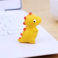 Süße Mini Dino Figur in Gelb mit roten Flossen auf einer Laptop Tastatur Deko - Gelb