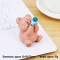 Pinkish brown cute resin bear figurine holding a dark blue bottle for desk decor - Dizzy Bear Style