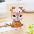 Cute deer bobblehead car ornament with purple floral headwear on a wooden desk - Open Eyes - Brown