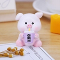 Cute pink resin pig figurine holding a purple cup as a desk ornament on wooden surface - Beauty Tea Pig Ornament
