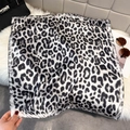 Classic leopard print square silk-like scarf on soft plush fabric with stylish bag background - Black