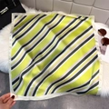 Detail of geometric lime green striped silk scarf on white plush background with handbag - Yellow-Green