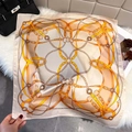 Detalle de un pañuelo de seda de lujo con cadena dorada y motivos ecuestres - 65*65cm / Albaricoque Beige