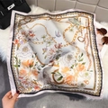 Detail of floral silk scarf with golden chains and vintage patterns on soft white carpet - 65x65 / Pink Trim